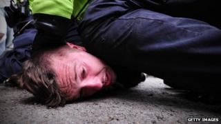 Police officer kneeling on man's head