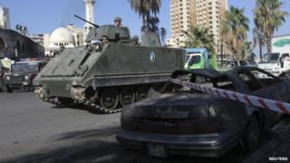 A Lebanese army armoured personnel carrier patrols the street in front of al-Takwa mosque where a second car bomb exploded in the port city of Tripoli in northern Lebanon 24 August, 2013