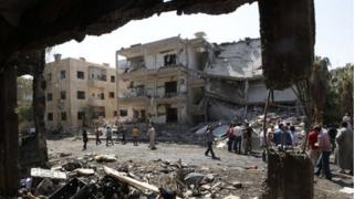 People inspect the damage at a site hit by what activists say was a car bomb in Raqqa province, eastern Syria August 29, 2013.