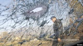 A policeman is seen through the damaged windshield of a car in Srinagar in this March 10, 2011 file photo