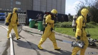Rescuers in chemical protection suits