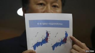 Vice-Minister of Maritime Affairs and Fisheries Son Jae-hak points at a document showing Japanese prefectures with import bans (in red) imposed by South Korea (L) and China (R) respectively at a news conference in Seoul on 6 September 2013