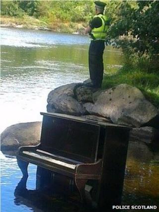 Officer Steve Band stands over the piano at the River Tay
