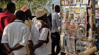 Locals look at newspaper headlines in Stone Town, where two young British women suffered an acid attack, on the Indian Ocean island of Zanzibar on 9 August 2013.