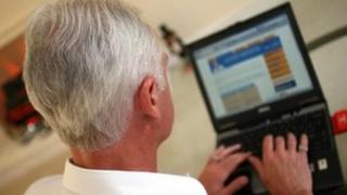 A man with grey hair using a laptop