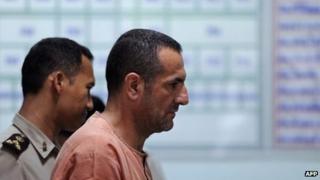 Lebanese-Swedish man Atris Hussein (C) leaves a holding cell for the courtroom ahead of a scheduled hearing at a criminal court in Bangkok on 11 June 2013