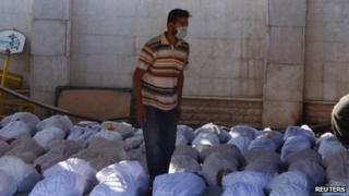 Сирийские активисты осматривают тела людей, которые, по их словам, были убиты нервным газом в регионе Гута