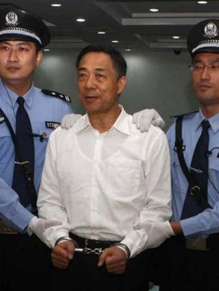 Bo Xilai (C) wearing a pair of handcuffs as he stands in a courtroom in Jinan, east China"s Shandong province