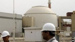 Iranian technicians walk outside the building housing the reactor of Bushehr nuclear power plant