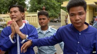 Born Samnang (left) and Sok Sam Oeun (right), are escorted by a prison guard to the supreme court in Phnom Penh on 25 September 2013