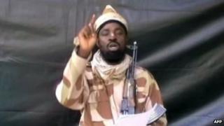 A grab taken from a video on 13 July 2013 shows the leader of the Islamist extremist group Boko Haram Abubakar Shekau dressed in camouflage and holding a Kalashnikov AK-47 rifle