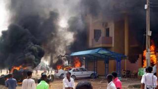 Cars burn in front of a building during protests over fuel subsidy cuts in Khartoum September 25, 2013.