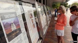 women look at newspapers