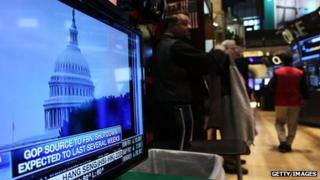 capitol building on screen in front of new york stock exchange floor