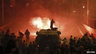 A riot police officer fires rubber bullets at members of the Muslim Brotherhood during clashes in Cairo October 6