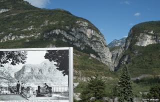 The Vajont dam is seen behind an old photo of Longarone, Italy, 26 September