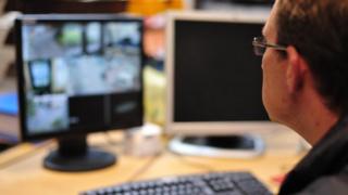 Man looking at CCTV monitor