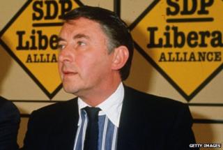 Sir David Steel wearing striped shirt with white tie.
