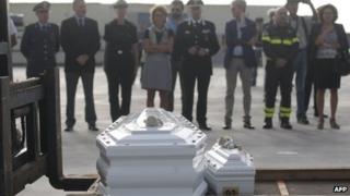 Officials pay their respect in front of the coffins of refugees who died trying to get to Lampedusa