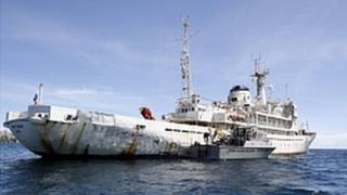 Venezuelan Coast Guard boat sits next to the 285-foot survey ship Teknik Perdana docked near the shore in Margarita Island, Venezuela, Sunday Oct. 13, 2013