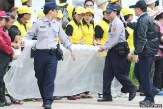 Police officers prepare a net to stop shoes thrown at President Ma Ying-jeou at the Taipei City Hakka Cultural Park on 20 October