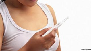 Женщина проверяет тест на беременность