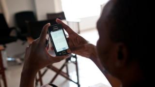 Женщина в Танзании с помощью мобильного телефона