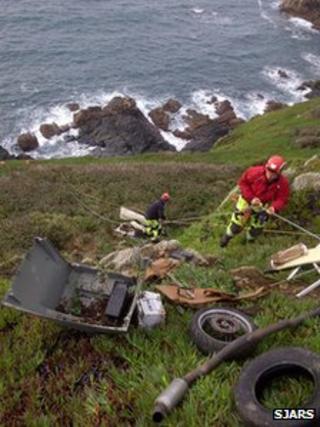Cliff rescue team members retrieving rubbish