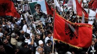 Косовские албанцы развевают албанские флаги и знамена, принимая участие в акции протеста в Приштине 27 мая 2013 года