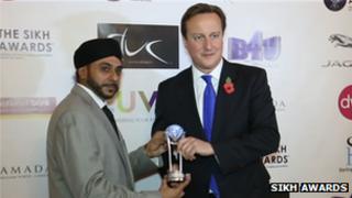 David Cameron receives his prize from Navdeep Singh, founder of the awards