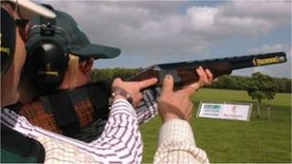 Person being coached in shooting shotgun