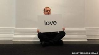Charles Frith holding printed word "love"