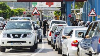 Members of the Guardia Civil check cars as motorists queue to cross the border between Spain and Gibraltar in La Linea de la Concepcion on August 22, 2013