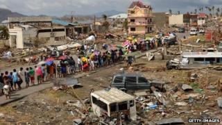 Survivors form a queue to receive relief goods at a devastated coastal area on November 16, 2013 in Leyte, Philippines.