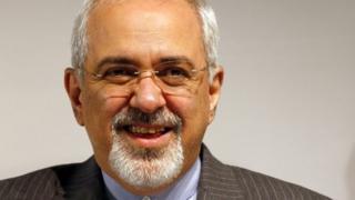 Iranian Foreign Minister Mohammad Javad Zarif smiles during a news conference after nuclear talks at the United Nations European headquarters in Geneva November 10, 2013.