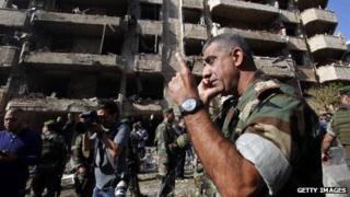 A Lebanese army soldier speaks on the phone in front of the damaged Iranian embassy in Beirut.