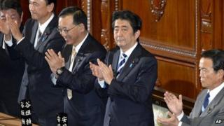 Japanese PM Shinzo Abe (second from right) claps with lawmakers from his Liberal Democratic Party after the secrecy law was approved in parliament's lower house
