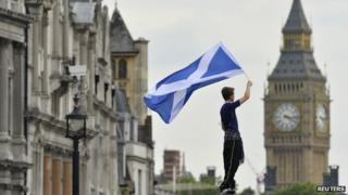 A boy waves the satire with Big Ben in the background