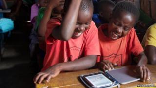 Children in Africa reading an e-book produced by the organisation Worldreader