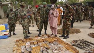 Military officials stand near ammunitions seized from suspected members of Hezbollah after a raid of a building in Nigeria's northern city of Kano May 30, 2013