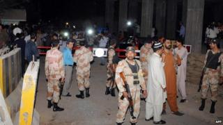 Pakistani paramilitary soldiers cordon off a local newspaper office building after men threw crackers in an attack in Karachi on December 2, 2013.