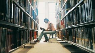 Dynes mewn llyfrgell. Llun: Thinkstock