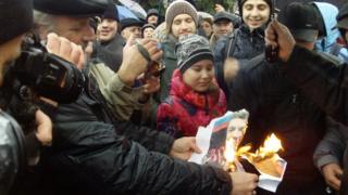 Protesters in Donetsk set fire to a picture of President Yanukovych