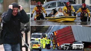 Composite image of a man holding onto his hat in the wind, a couple being rescued from their home by boat and police inspecting an overturned lorry which has crushed two cars