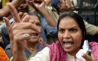 Activist argues with police officials outside the court after a suspect in the gang-rape of a female photographer was produced, in Mumbai