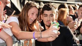 Fan taking a picture with One Direction