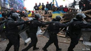 Riot police march past protesters in Independence Square, Kiev, on 11 December 2013