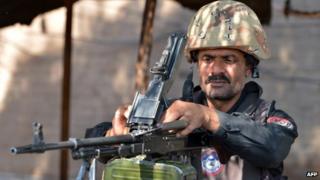A Pakistani policeman loads his gun at a security check point in northern Pakistan (November 2013)