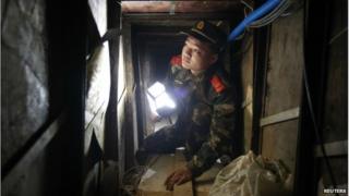A policeman inspects a tunnel which was built by smugglers near the border of Hong Kong, in Changling village of Shenzhen, Guangdong province December 24