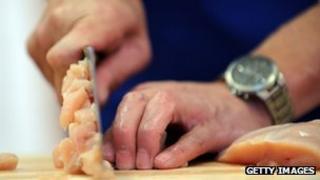 man cutting chicken